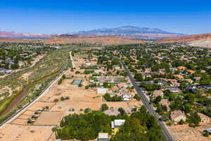Aerial view of property and surrounding area with mountains and nearby suburban area