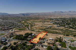 Aerial overview of property's location with nearby suburban area, mountains, and property boundaries highlighted