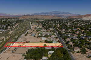 Aerial overview of property's location with a mountain backdrop and property boundaries highlighted