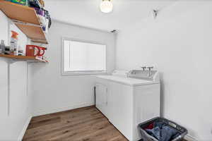 Washroom featuring dark wood-type flooring and independent washer and dryer
