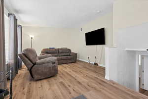 Living room featuring light wood-style floors and baseboards