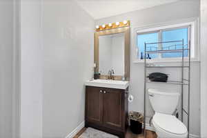 Half bathroom featuring vanity, a textured ceiling, and dark wood-style floors
