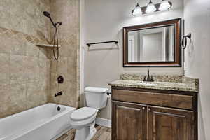 Full bath with bathtub / shower combination, vanity, and wood finished floors