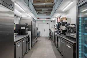 Kitchen with stainless steel fridge, high quality fridge, a wall mounted AC, and stainless steel countertops