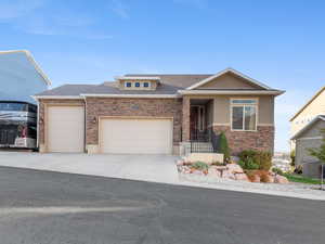 View of front of property featuring an attached garage, concrete driveway, roof with shingles, and brick siding