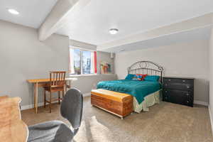 Bedroom featuring carpet and beam ceiling