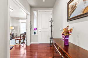Entryway featuring dark wood finished floors and baseboards