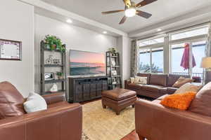 Living room featuring a textured ceiling, wood finished floors, recessed lighting, and ceiling fan