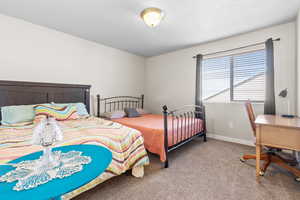 Carpeted bedroom with baseboards and a textured ceiling
