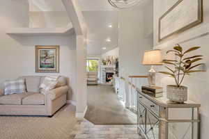 Living area with carpet floors, recessed lighting, and a stone fireplace