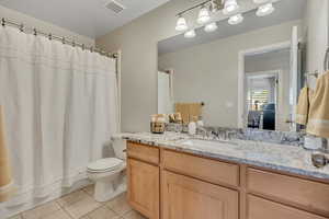 Bathroom with light tile patterned flooring and vanity
