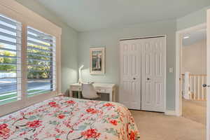 Bedroom featuring light carpet, a closet, and access to outside