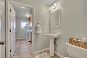 Bathroom featuring light tile patterned floors and washer and dryer
