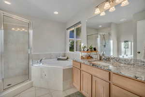 Bathroom featuring vanity, a stall shower, light tile patterned flooring, a bath, and recessed lighting