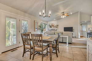 Dining room featuring lofted ceiling, light tile patterned flooring, plenty of natural light, a chandelier, and recessed lighting