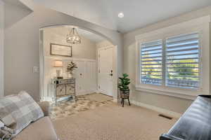 Carpeted foyer entrance with baseboards and recessed lighting