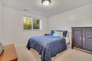 Carpeted bedroom featuring baseboards and a textured ceiling