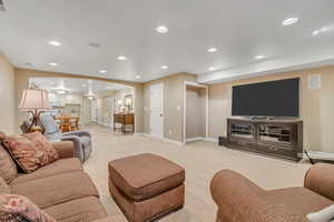 Living area featuring arched walkways, recessed lighting, and light carpet