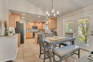 Dining space featuring recessed lighting, light tile patterned flooring, a chandelier, and lofted ceiling