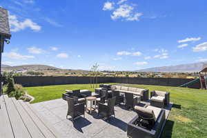 Fenced backyard with a mountain view, an outdoor hangout area, and a patio