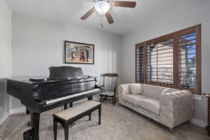 Sitting room with carpet floors and a ceiling fan