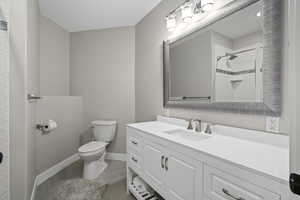 Full bath featuring vanity, tiled shower, and light tile patterned floors
