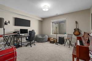 Home office with light colored carpet and baseboards