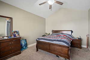 Bedroom with vaulted ceiling, carpet, and ceiling fan