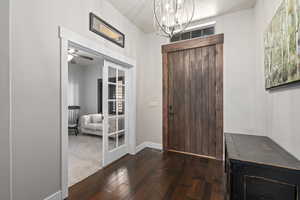 Entrance foyer featuring dark wood-type flooring, a chandelier, and ceiling fan