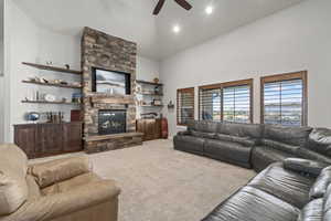 Living area featuring light colored carpet, a fireplace, ceiling fan, and recessed lighting