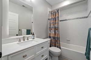 Full bathroom with shower / bath combo with shower curtain and vanity