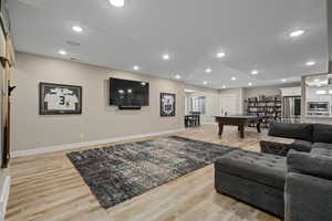 Living area with light wood-style floors and recessed lighting