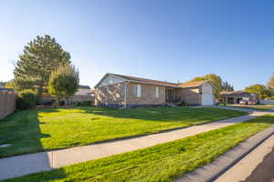 View of front of home with brick siding, a garage, and driveway