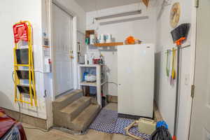 Garage work space including free-standing freezer.