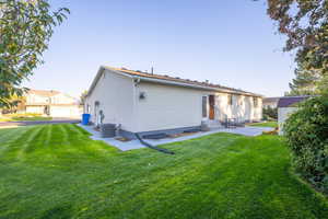 Back of property with a yard, entry steps, and an outdoor structure