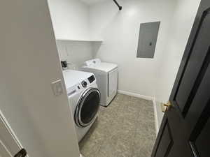 Laundry room with electric panel and washing machine and clothes dryer