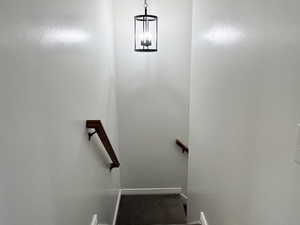 Stairway featuring a textured ceiling and carpet flooring