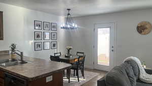Dining room with a textured ceiling, a chandelier, and tile patterned floors