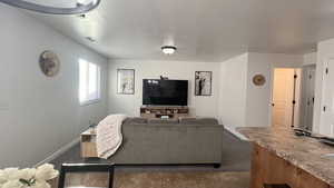 Living area featuring a textured ceiling and dark tile patterned flooring