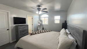 Bedroom with a textured ceiling and a ceiling fan