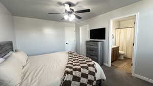 Carpeted bedroom featuring ceiling fan and ensuite bathroom