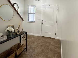 Foyer entrance featuring a textured ceiling and dark tile patterned floors