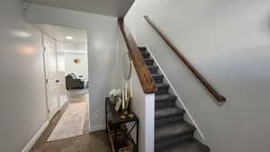 Staircase with tile patterned floors and recessed lighting