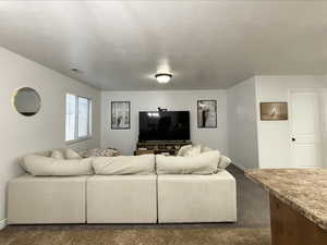 Living room featuring a textured ceiling and baseboards