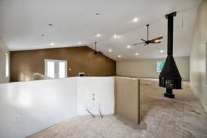 Shop loft with a wood stove, lofted ceiling, ceiling fans, french doors, and area for a kitchen