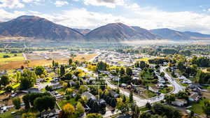 Aerial view of property and surrounding area with nearby suburban area and mountains