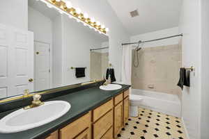 Upstairs bathroom featuring shower / bathtub combination with curtain and double vanity