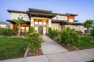 Contemporary home featuring a front lawn and stucco siding