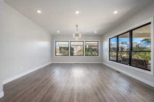Spare room featuring a chandelier, recessed lighting, and wood finished floors