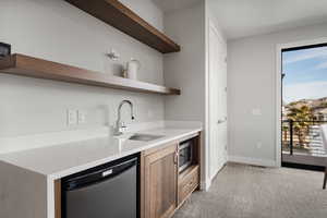 Kitchen with open shelves, stainless steel appliances, light carpet, and light stone countertops